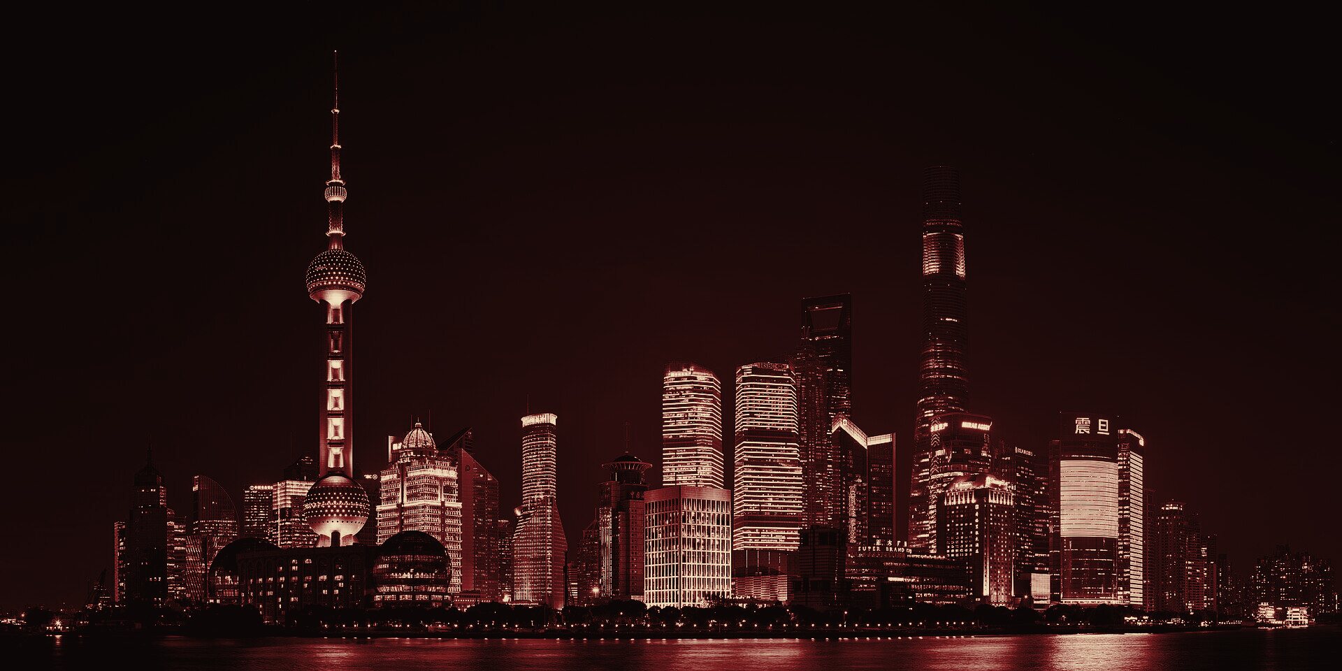The illuminated skyline of Lujiazui, Shanghai's financial district, graded as a red-and-gold duotone film still