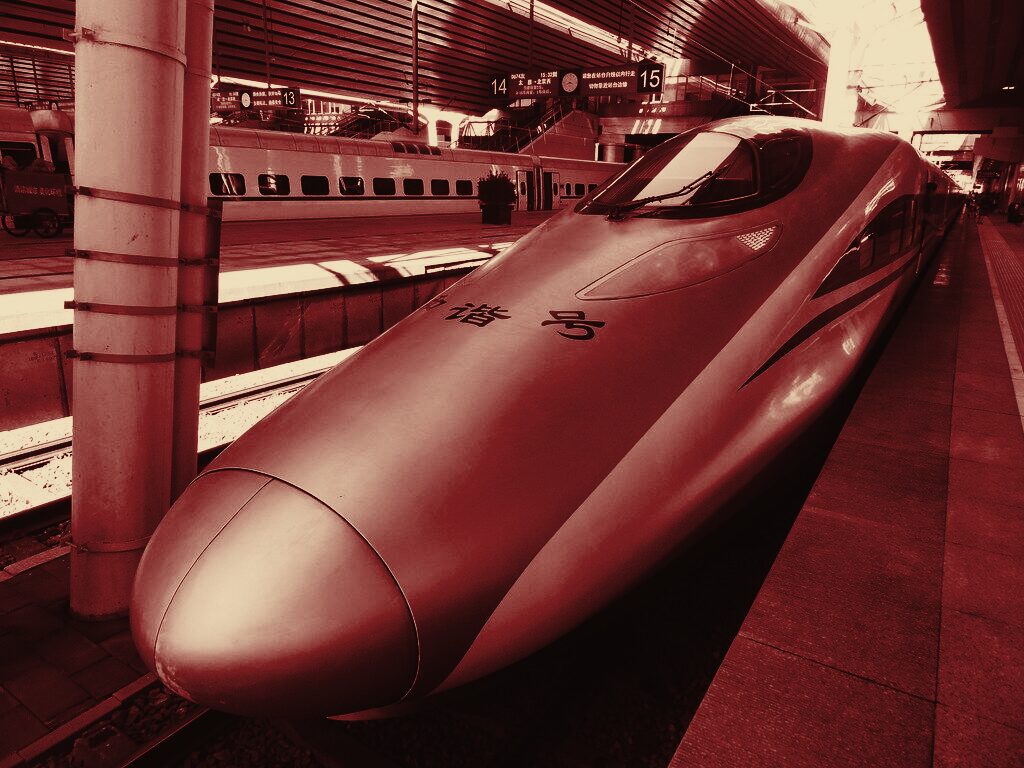 A Fuxing CR400 high-speed train at a platform, in duotone grade